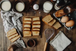 Ingredients for French toast without milk on a wooden kitchen counter.